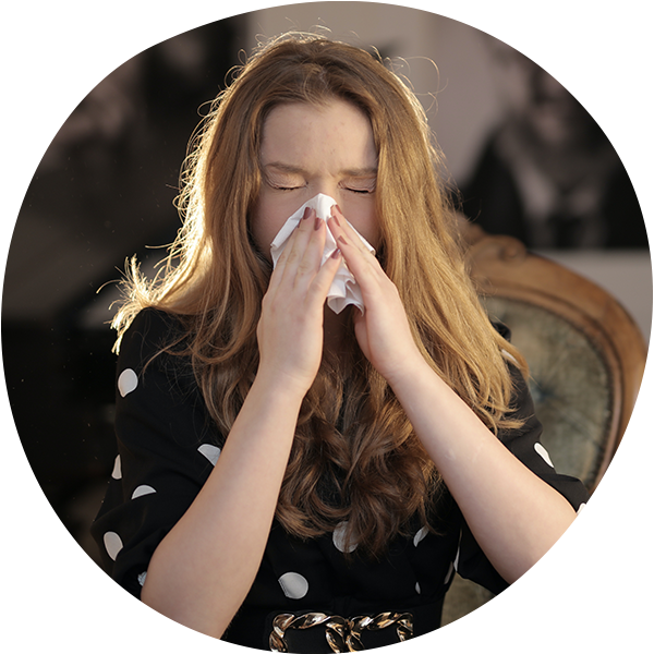 young woman blowing her nose into a tissue